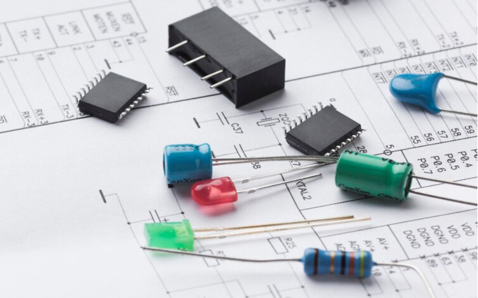 Electronic components (resistors, capacitors, ICs) placed on a circuit schematic, illustrating hardware assembly.