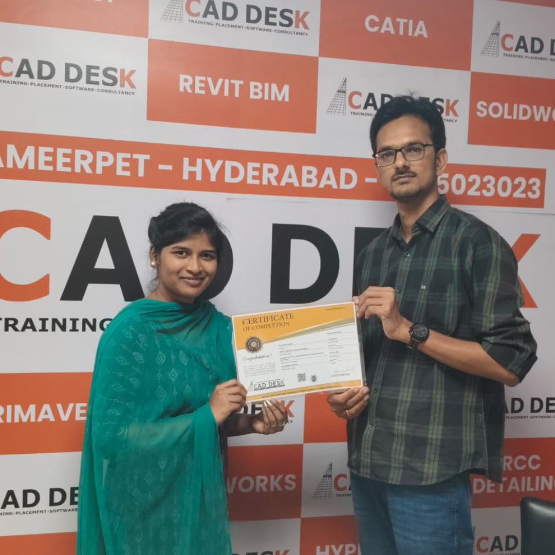Two people pose with a certificate in front of a CAD DESK backdrop; a man in a plaid shirt hands it to a woman in teal attire.
