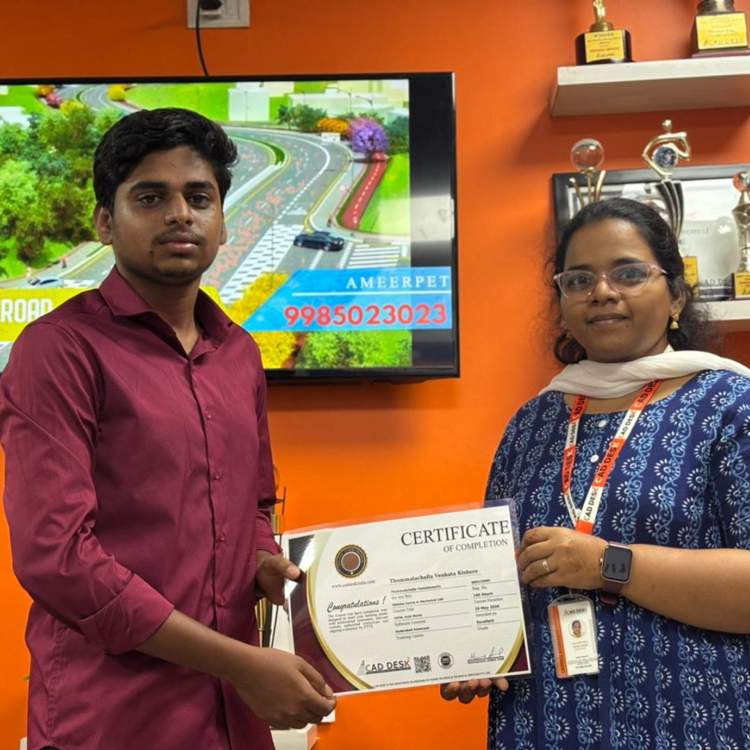 Man in a maroon shirt receives a certificate from a woman in a blue patterned dress indoors, orange wall and trophies behind them.